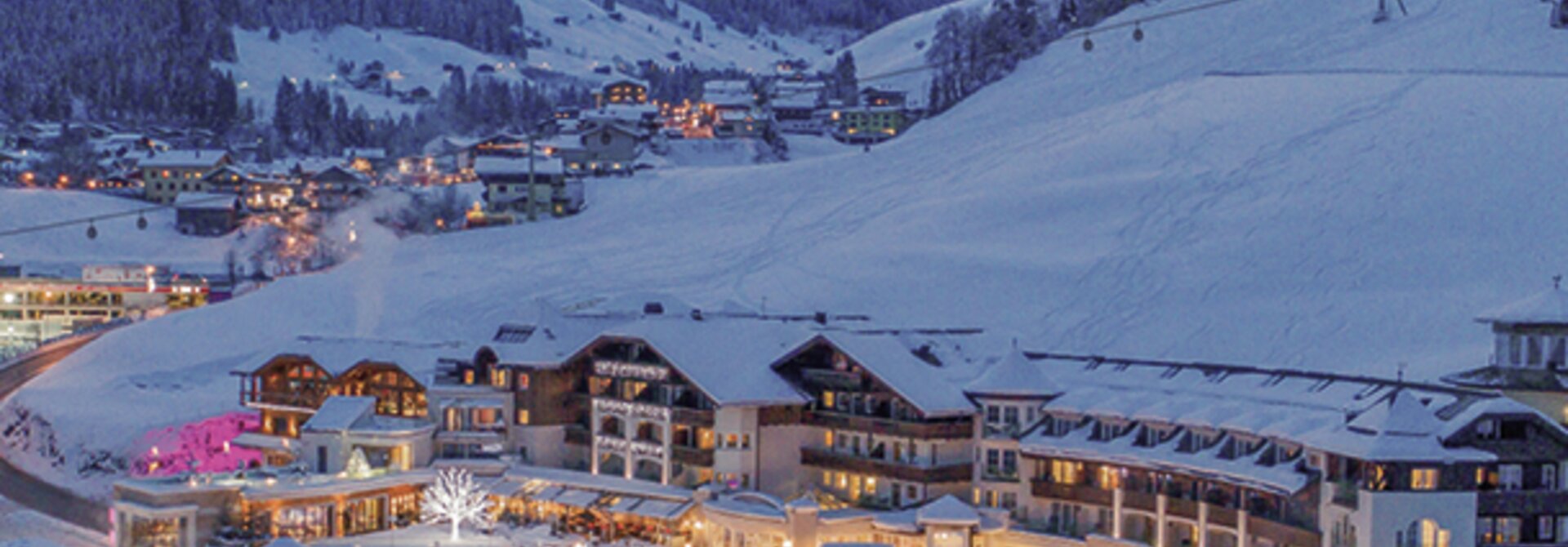 Hotelanlage im Winterort mit schneebedeckten Bergen im Hintergrund