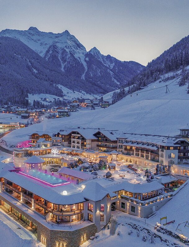Hotel complex in winter resort with snow-capped mountains in the background