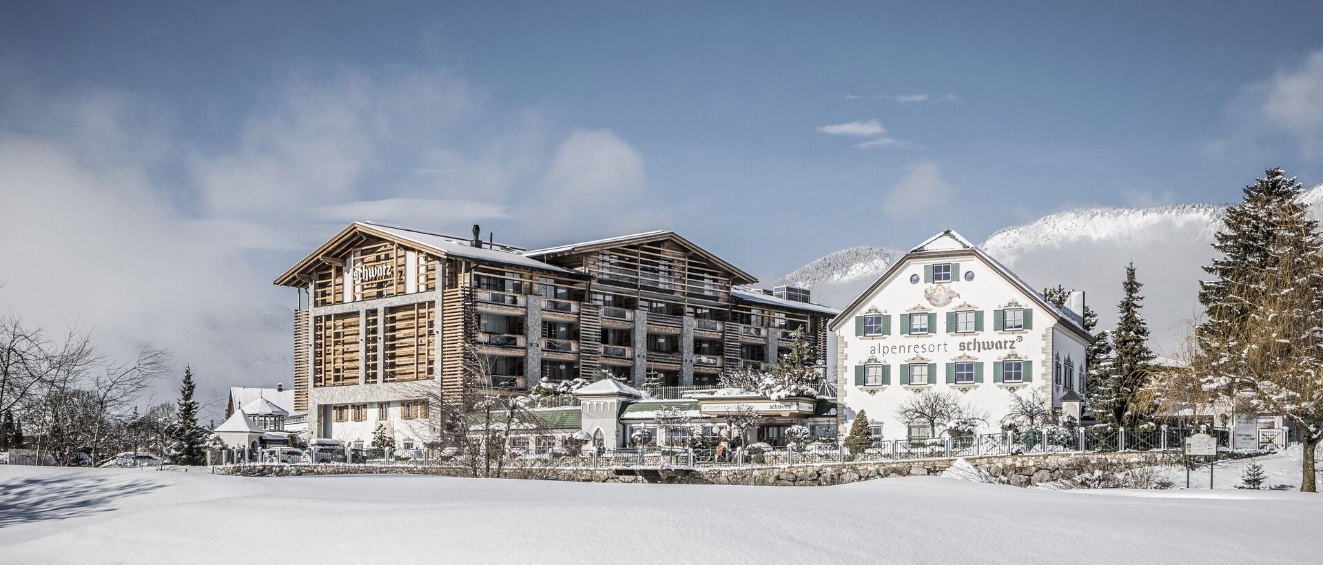 Alpenresort Schwarz  im Winter mit Schnee bedeckt unter blauem Himmel