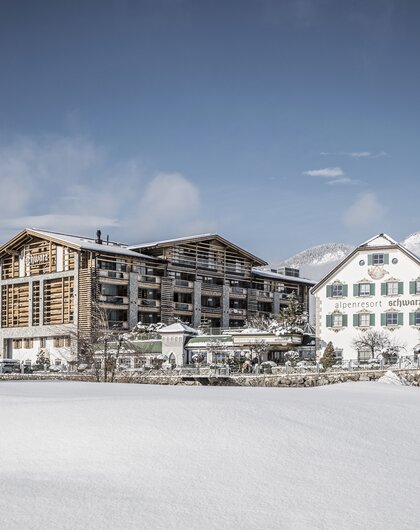 Alpenresort Schwarz  im Winter mit Schnee bedeckt unter blauem Himmel