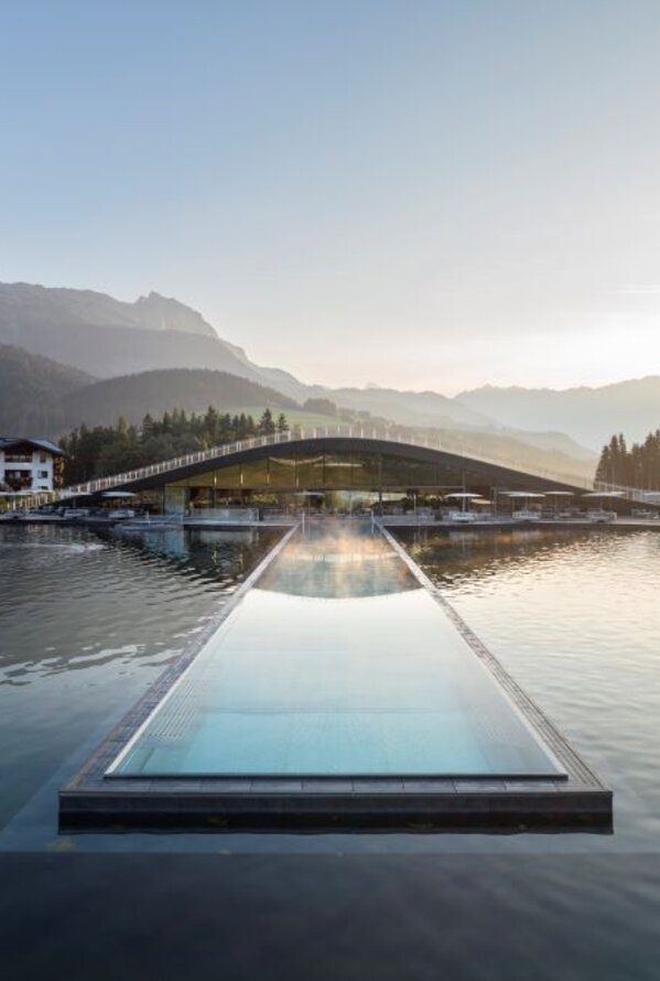 Infinity-Pool im Krallerhof mit Blick auf Berglandschaft und See im Sommer