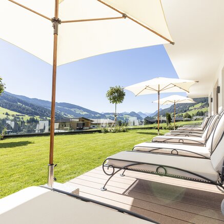 Relaxing terrace with comfortable lounge chairs and beautiful mountain views.