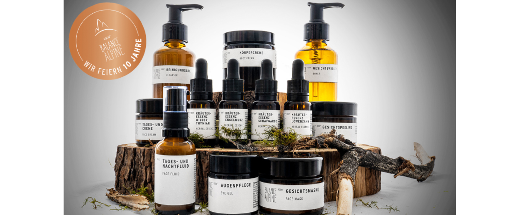 Kosmetikprodukte auf Holzstämmen und Zweigen mit Jubiläumslogo