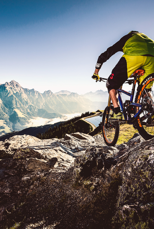 Mountainbiker auf Felsen vor Bergpanorama