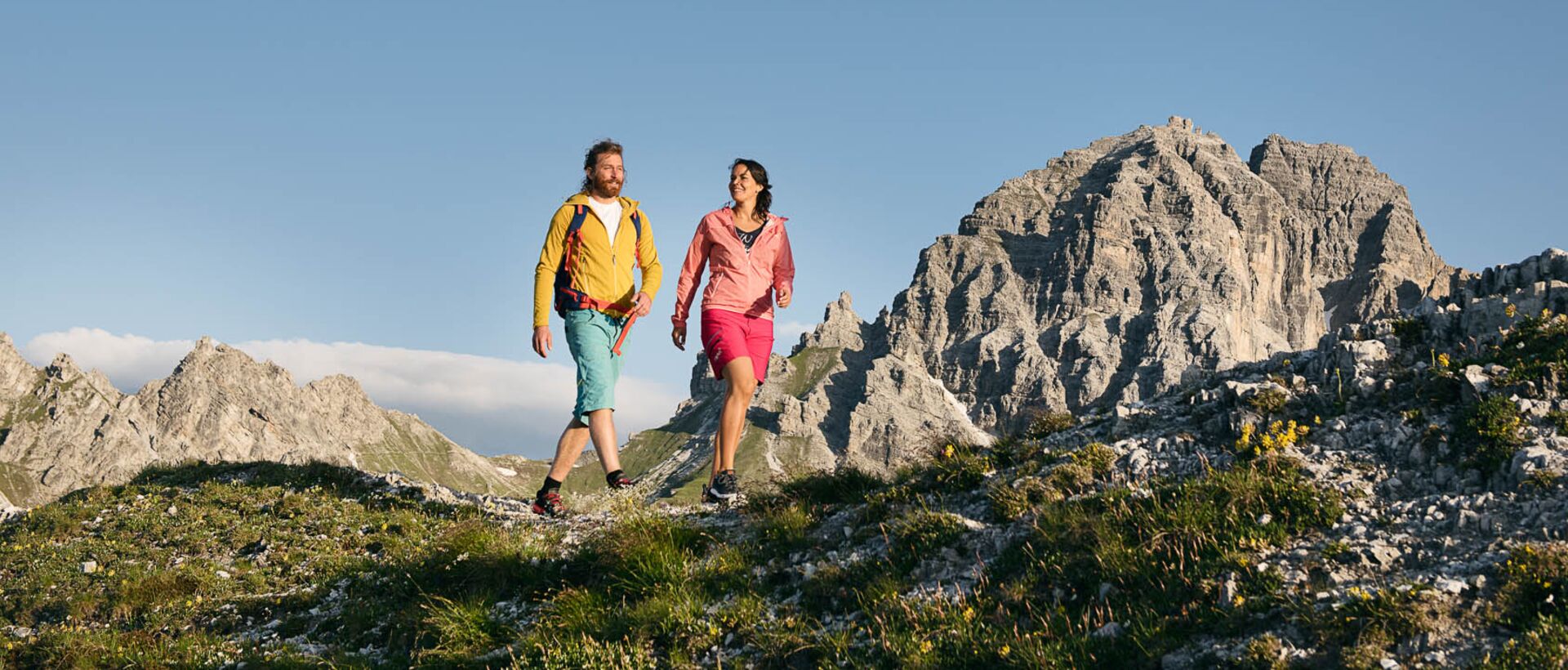 Hiking couple in mountain landscape against blue sky