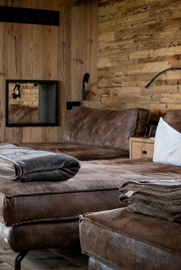 Gemütlicher Wellness-Ruheraum mit bequemen Liegen und warmem Holzinterieur.