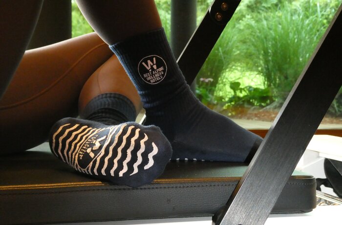 Pilates-Socken der Best Alpine Wellness Hotels beim Training auf einem Reformer.
