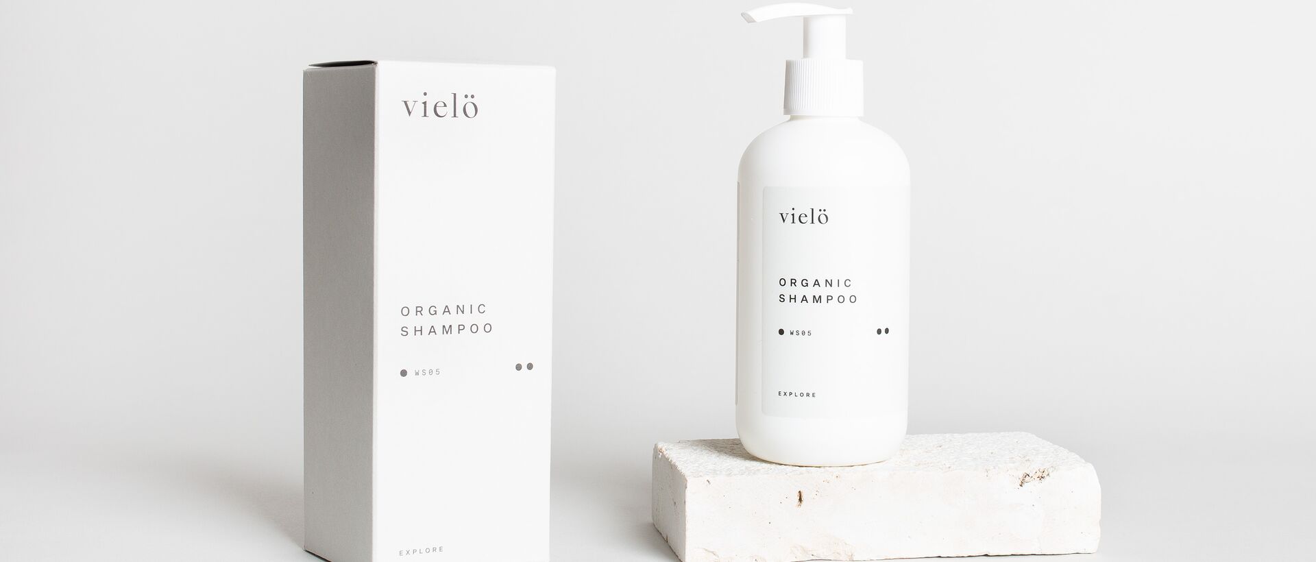 Weißes Shampoo mit Spender und Verpackung von vielö vor hellem Hintergrund