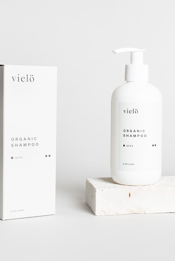 Weißes Shampoo mit Spender und Verpackung der Marke vielö vor hellem Hintergrund