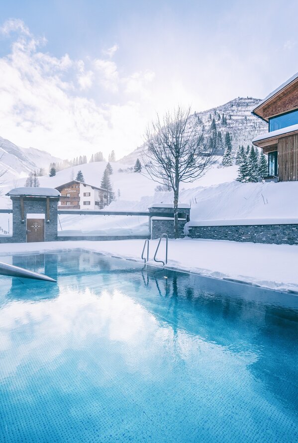 Heated outdoor pool in snowy landscape | Wellnesshotel Warther Hof, Arlberg