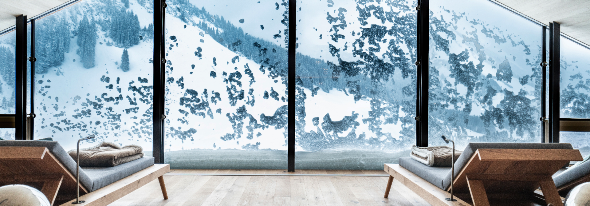 Helle Holzlounge mit Panoramablick auf verschneite Berge