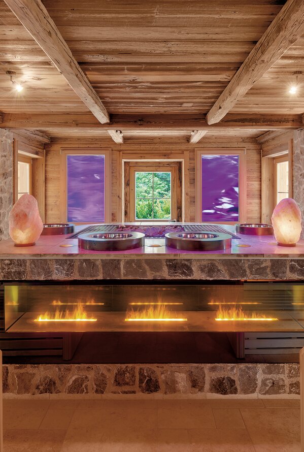 Cozy alpine sauna with warm wooden interiors and a relaxing fireplace ambiance.