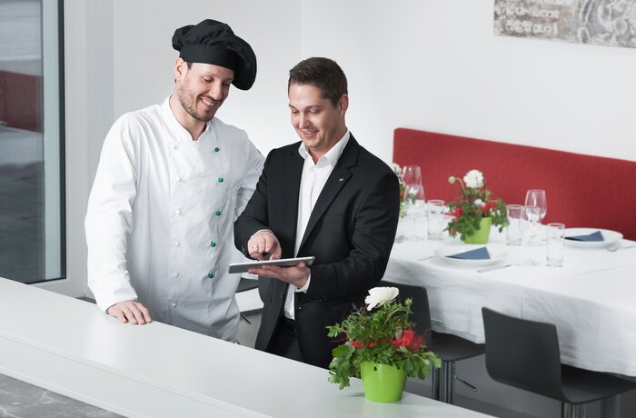 Koch und Fachberater mit Tablet in Gastronomiebetrieb