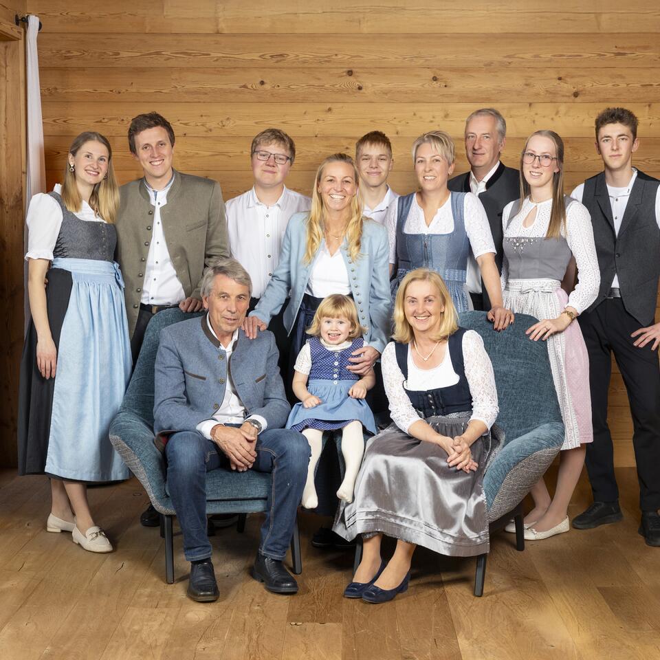 Familienporträt mit mehreren Generationen in traditioneller Kleidung.