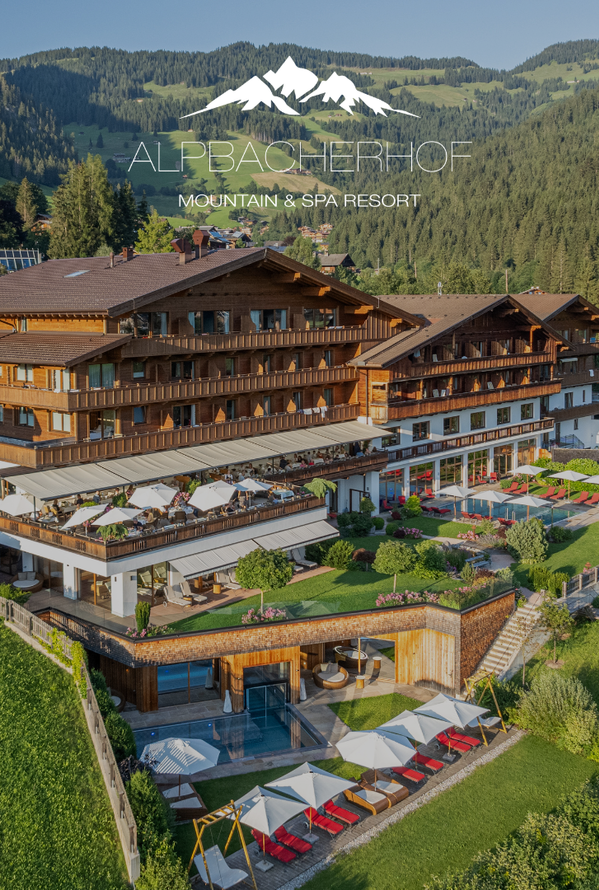 Luftaufnahme eines Resorts mit Poolbereich, Sonnenterrassen und Berglandschaft