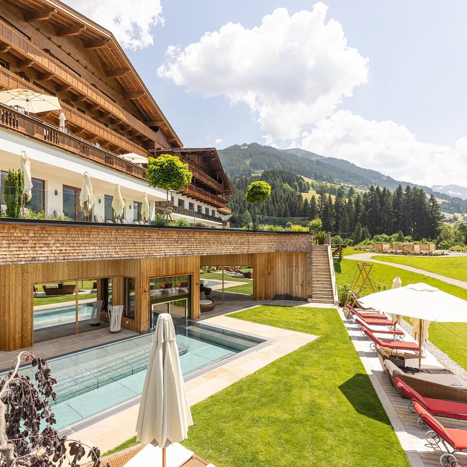 Hotel Alpbacherhof mit Pool, Liegen und Garten im Adults Only Bereich vor Bergkulisse