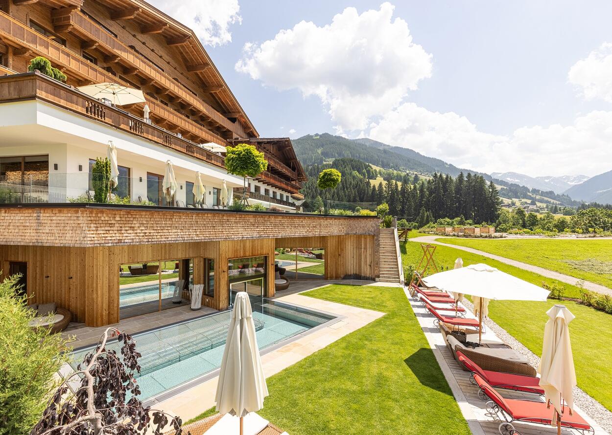 Hotel Alpbacherhof mit Pool, Liegen und Garten im Adults Only Bereich vor Bergkulisse
