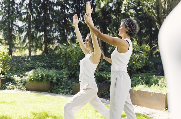 Sabrina hilft Frau bei Yoga position | Luxury Hideaway & Spa Retreat Alpenpalace, Wellnesshotel Südtirol 