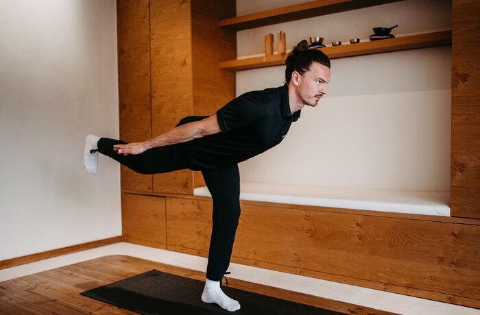 Mann macht Yogaübung im Raum