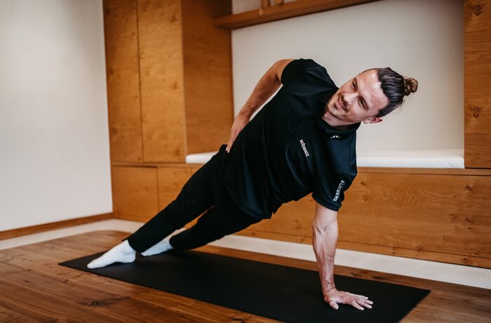 Mann macht seitlichen Unterarmstütz auf Yogamatte