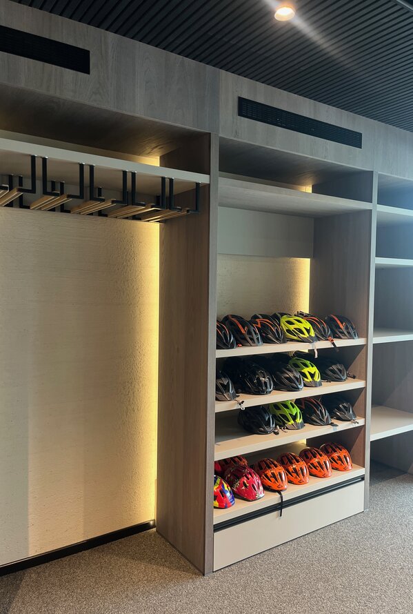 Cabinet with bicycle helmets and clothes rail, illuminated
