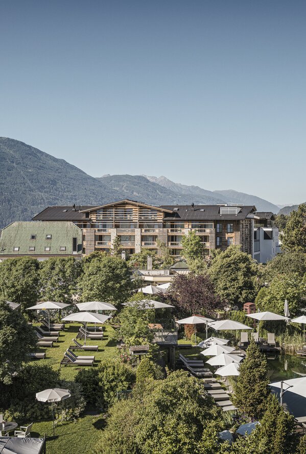 Alpenresort Schwarz with pool, loungers and mountain views on a sunny day