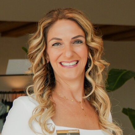 Frau mit blonden Locken lächelt in die Kamera