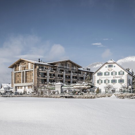 Alpenresort Schwarz  im Winter mit Schnee bedeckt unter blauem Himmel