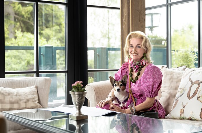 Elisabeth Gürtler mit Hund auf dem Schoß vor Fenster