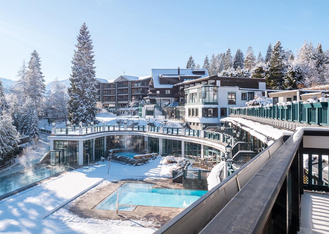 Winter exterior view of the Alpin Resort Sacher with pool and snow-covered buildings
