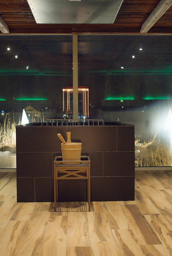 Sauna mit Dusche, Holzboden, großem Fenster mit Blick auf verschneite Landschaft