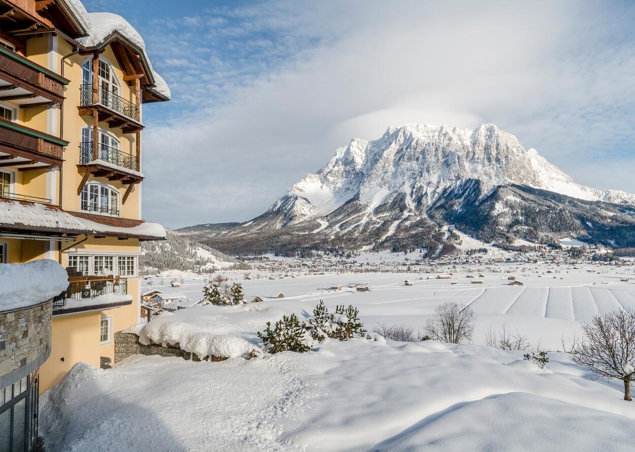 Winterliche Ansicht des Hotel Post vor schneebedeckter Bergkulisse