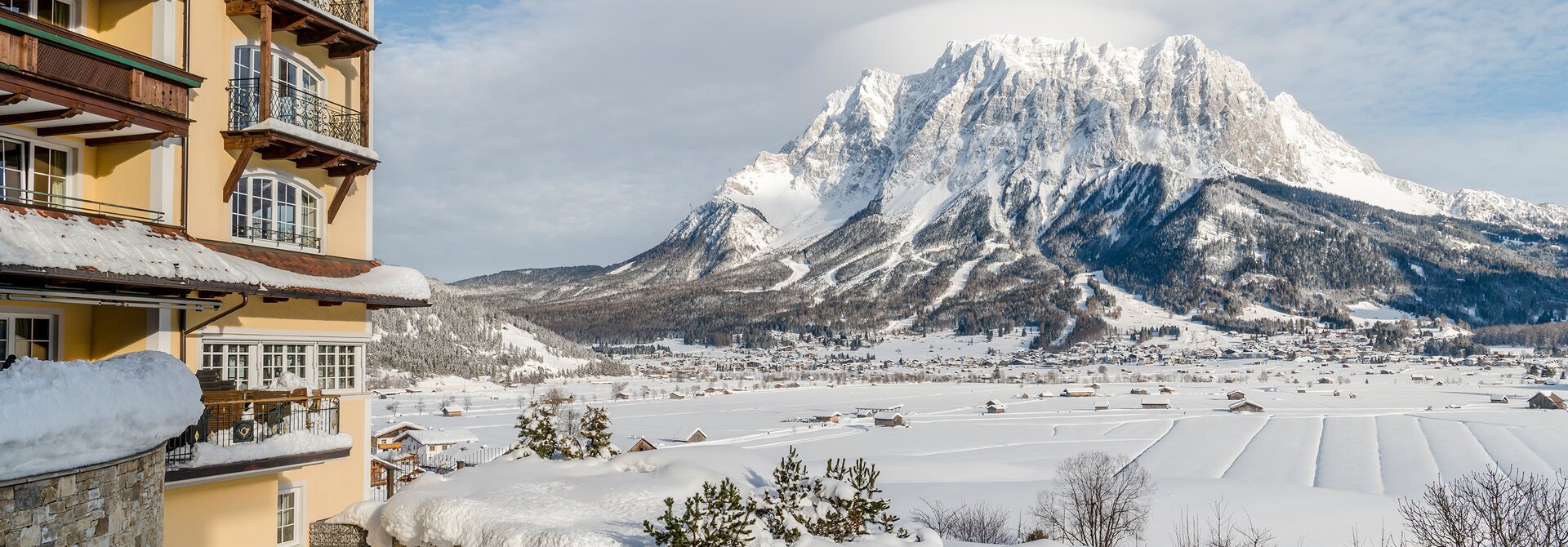 Winterliche Ansicht des Hotel Post vor schneebedeckter Bergkulisse