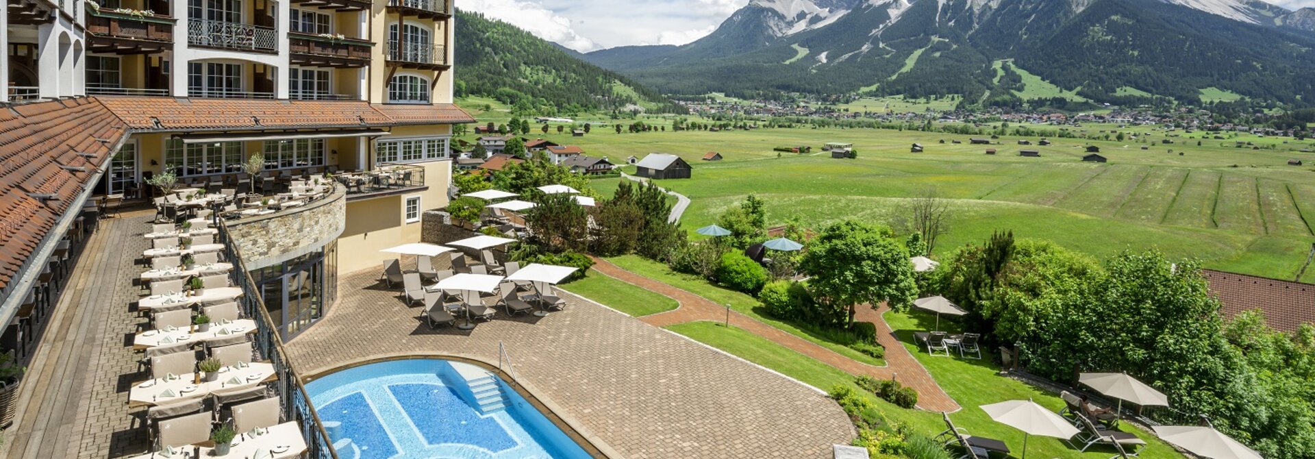 Hotel Post Lermoos mit Pool und Blick auf grüne Landschaft und Bergpanorama