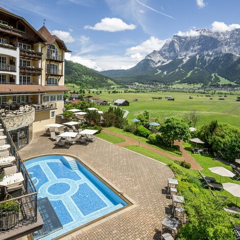 Hotel Post Lermoos mit Pool und Blick auf grüne Landschaft und Bergpanorama