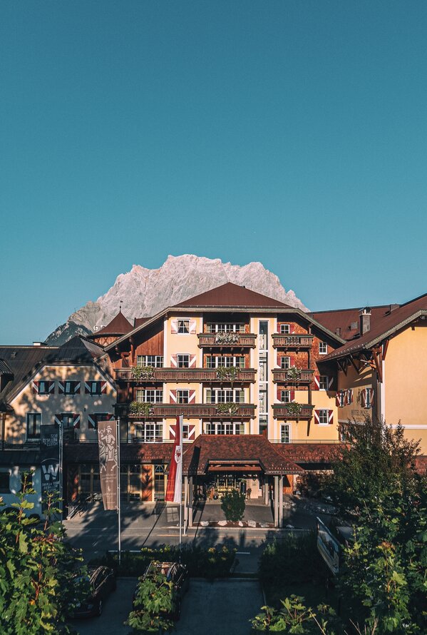 Hotelanlage in alpiner Umgebung mit beeindruckender Bergkulisse im Hintergrund.
