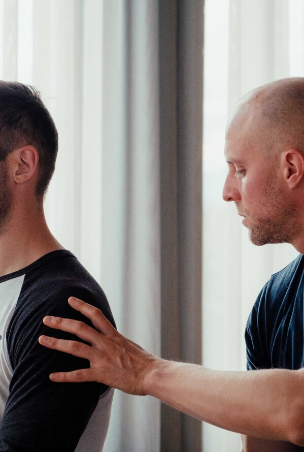 Ein Trainer begleitet Menschen bei einer ruhigen Meditations- oder Atemübung.