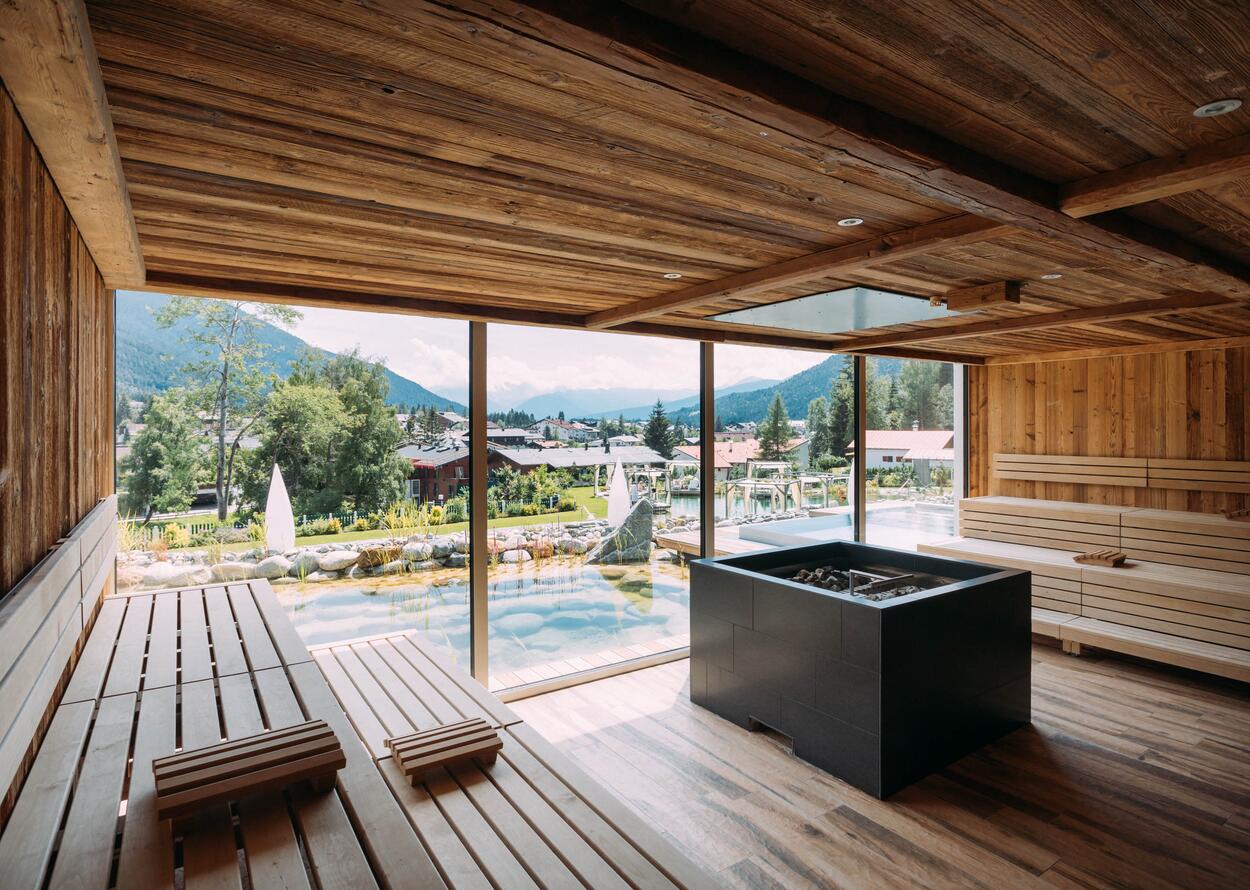 Sauna mit Holzbänken und Panoramablick auf eine Berglandschaft