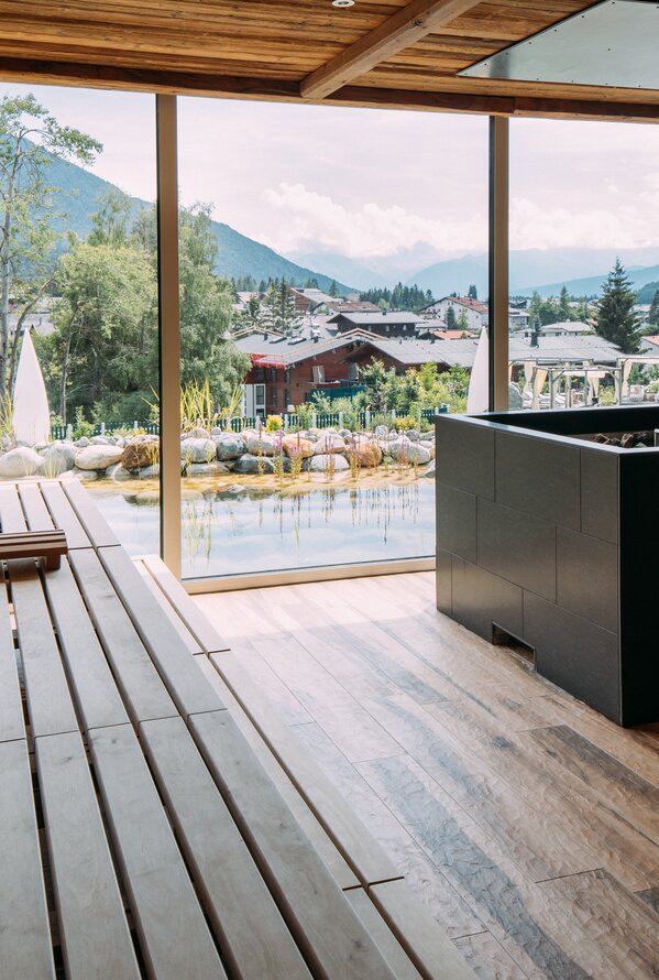 Moderne Sauna mit Panoramablick auf Berge und Natur.