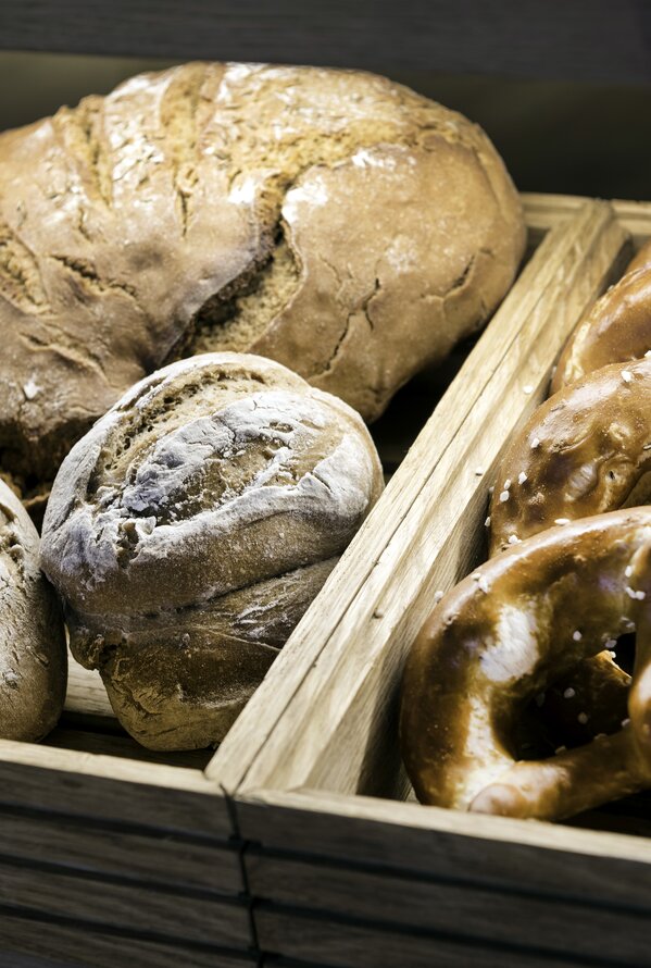 Fresh bread and pretzels in wooden crates on a buffet table