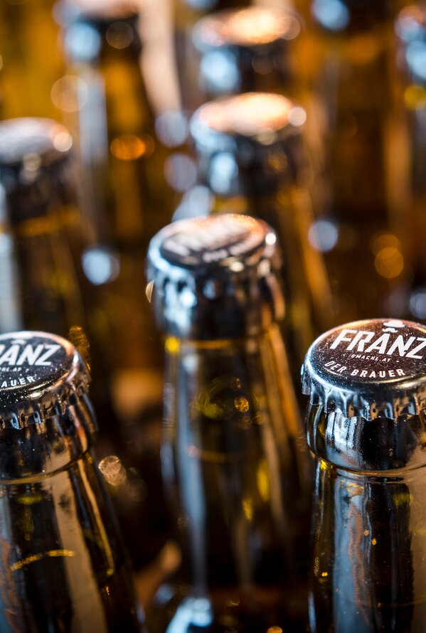 Handwerklich gebraute Bierflaschen mit individuell gebrandeten Kronkorken der Hausbrauerei FRANZ.