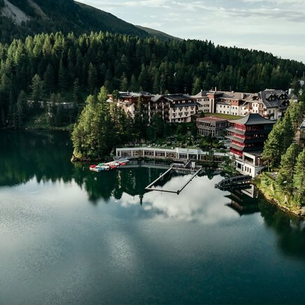Hotelanlage am See, umgeben von Wald und Bergen