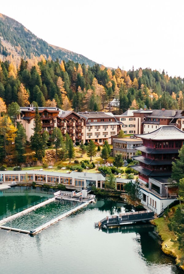 Ein idyllisches Resort liegt eingebettet zwischen herbstlichen Wäldern und einem ruhigen Bergsee.