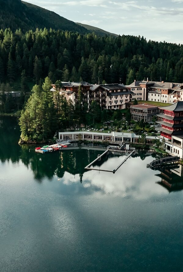 Hotelanlage am See, umgeben von Wald und Bergen