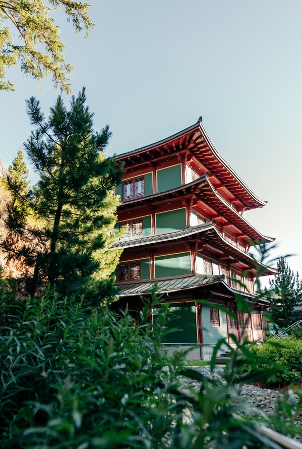 Asiatisch inspirierter Pagodenbau eingebettet in eine grüne Naturlandschaft.