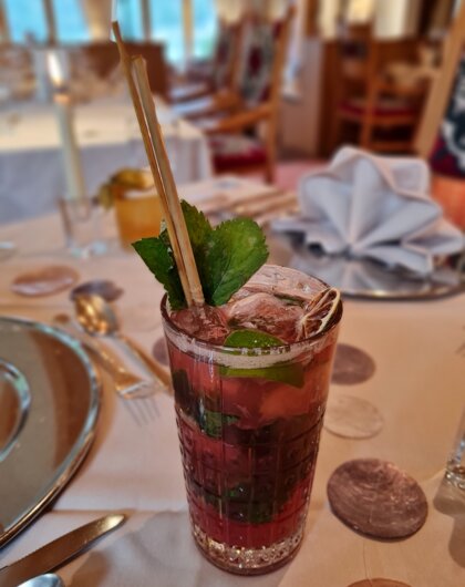 Cocktail mit Minze und Strohhalm auf einem Tisch
