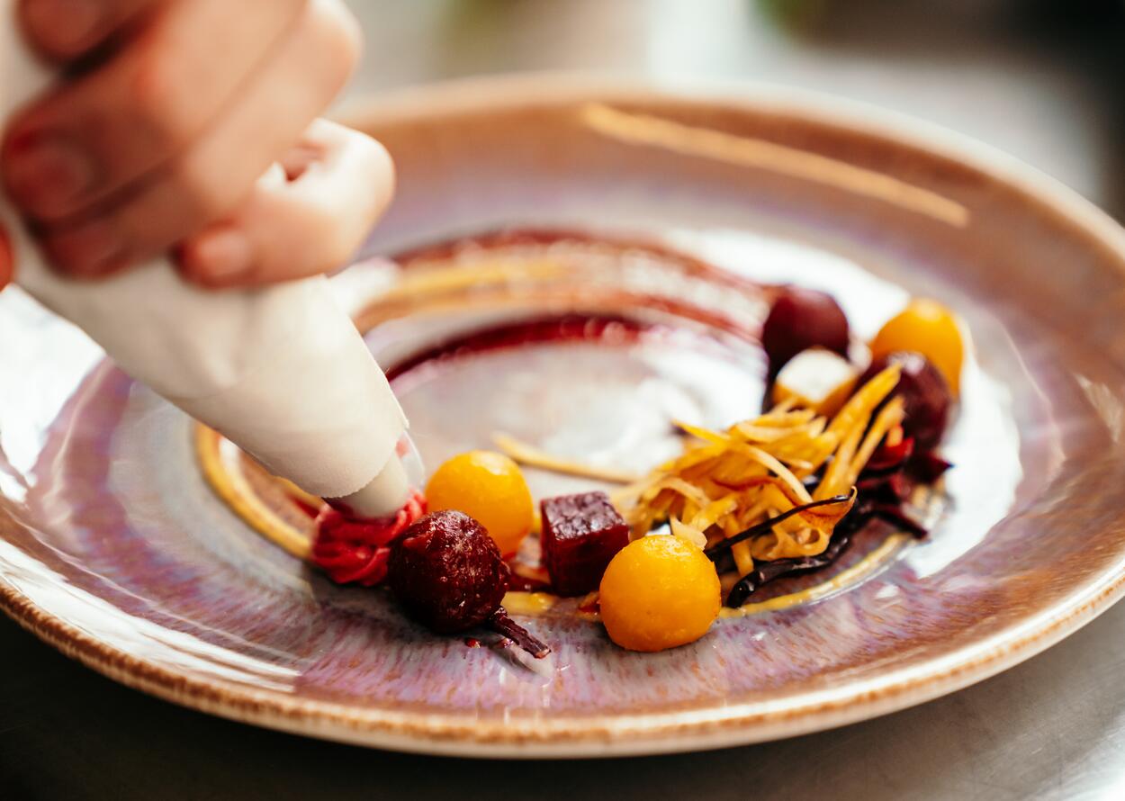 Kreativ angerichtetes Gourmetdessert mit feinen Details und moderner Präsentation.