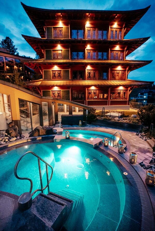 Asiatisch anmutendes Hotel mit Pool bei Dämmerung