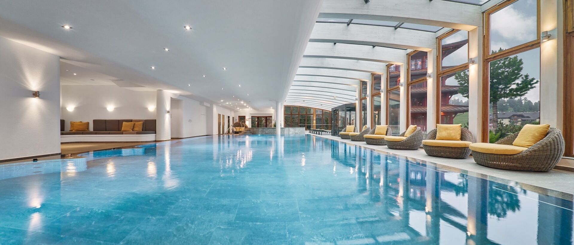 Weitläufiges Hallenbad mit Liegen unter Glasdach