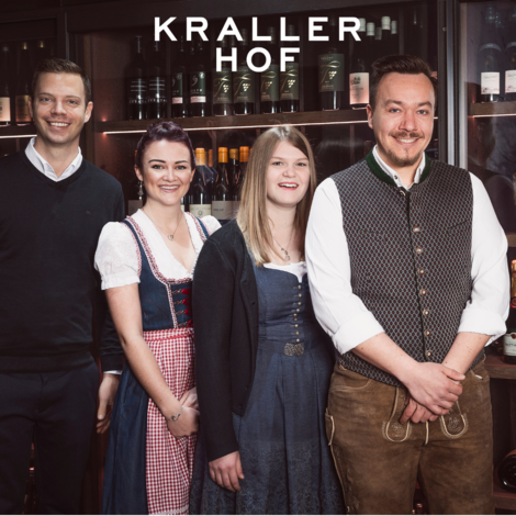 Vier Personen vor Weinregal mit Schriftzug Krallerhof